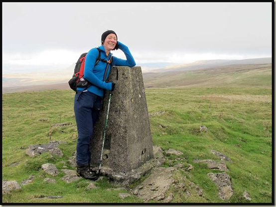 Heather reaches the trig point at 593 metres
