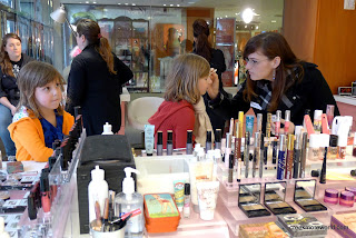 The girls get advice at the make-up counter in Union Square, San Francisco