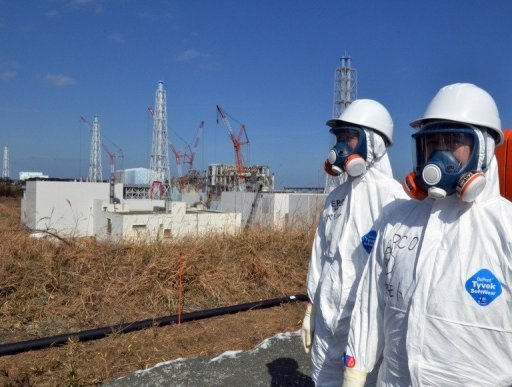 Tokyo Electric Power Co (TEPCO) workers stand before the stricken Fukushima nuclear plant on 28 February 2012. Yoshikazu Tsuno / AFP