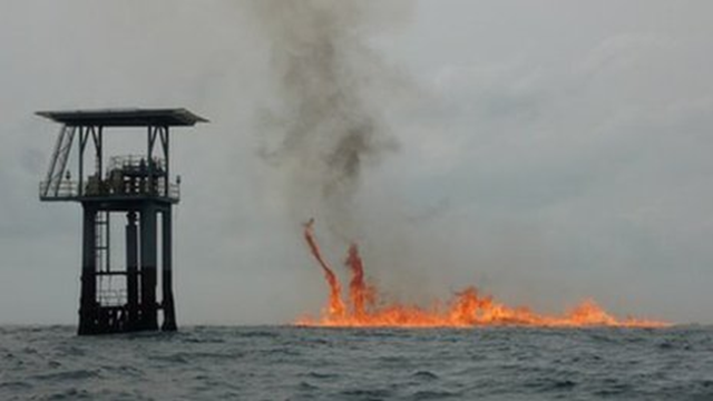 Fire burns on the ocean surface after the wreckage of the Chevron Nigeria gas exploration rig KS Endeavour sank. Local people fear that the fire may have contaminated the fish they normally eat. BBC