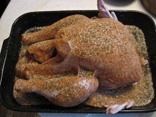 The raw turkey is covered in Cajun spices.