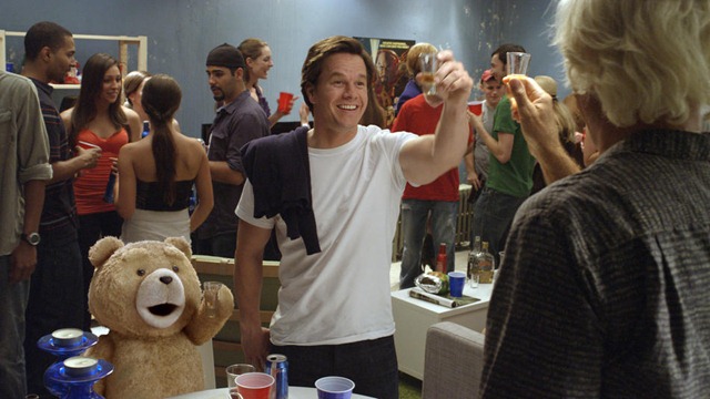 John (MARK WAHLBERG) and his best friend, Ted (voiced by SETH MACFARLANE), do rum shots with the real Flash Gordon (SAM JONES) in the live action/CG-animated comedy "Ted".