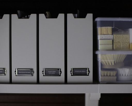 High shelving on both sides of the room is the perfect place for storing extra supplies and items not frequently accessed.  These wood magazine files from Home Decorator's Collection (homedecorators.com) are labeled and keep manuals and repair records organized.