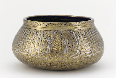 Bowl | Origin:  Iran | Period: mid 14th century | Details:  Not Available | Type: Brass, inlaid with silver, gold and a black organic material | Size: H: 12.0  W: 23.0   D: 23.0  cm | Museum Code: F1980.25 | Photograph and description taken from Freer and the Sackler (Smithsonian) Museums.