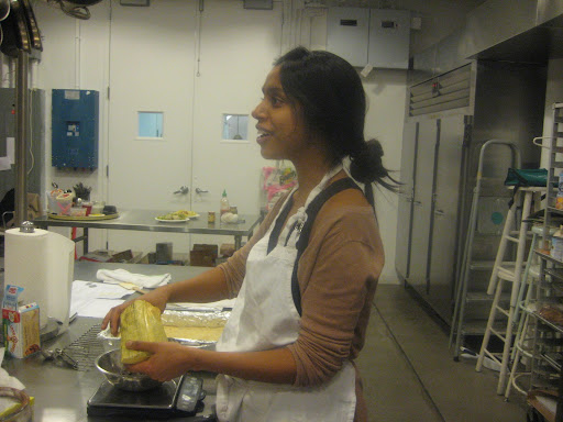 Sam Seneviratne getting into the spirit while she measures chocolate for her pecan bars.