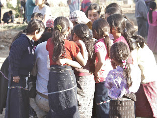 Jason (checked hat at top center) showing the pictures he took to dozens of children. Photos by TOM HART