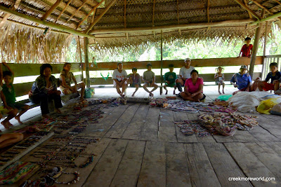 A small village and their crafts.  THe girls buy bracelets and we buy 3 ant-infested blowguns.
