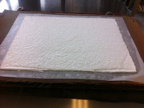 We build a stack of these wet sheets, called a post, sandwiched in between pelons (for a smoother texture) and felts (to absorb extra water).  At this point, the sheet is still 80% water.