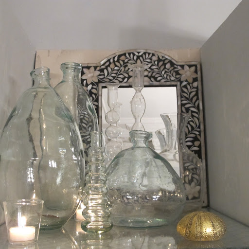 I gathered bottles, vases and candlesticks from around my house to make this collection on the top shelf that was too tall to serve any real bar function.