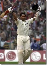Tendulkar with his arms aloft after completing his first Test ton at Kolkata