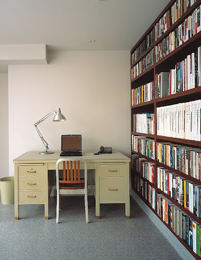 A home office, the floor-to-ceiling bookcase, built from ecologically grown South American teak, was custom-made to fit the space.