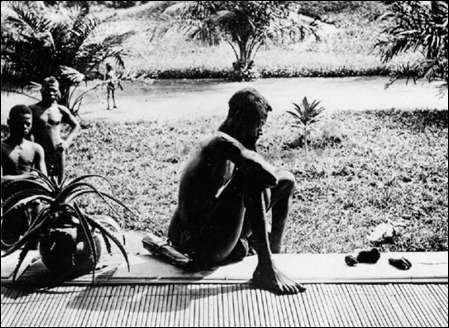 pai observa as mãos cortadas á filha de 5 anos como castigo por ter apanhado pouca borracha no Congo Belga