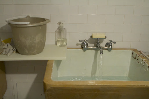 Uncle Carlos is filling the wash sink with warm water.