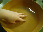 Soaking and rehydrating one spring roll wrapper at a time in cool water.