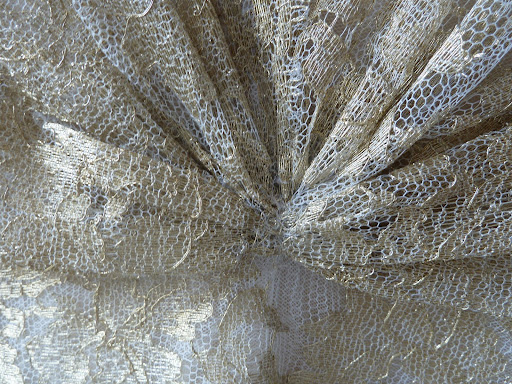 A close-up of the gold lace dress from Naeem Khan.