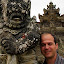 Darin With A Stone Guardian At The Temple - Bali, Indonesia