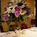 Tall glass stand with lilac, white flowers cascading.jpg
