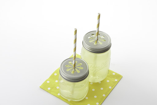 Serve your drinks in style with daisy-cut Ball jars. These come in two sizes. I like the big ones for adult cocktails and the little ones for kids’ lemonade. Our yellow swizzle straw fits right inside for easy sipping. These jars are reusable so keep them year round, or send them home with your guest as a cute favor. (Jars, straws, and napkins included in sale.) Serve your drinks in style with daisy-cut Ball jars. These come in two sizes. I like the big ones for adult cocktails and the little ones for kids’ lemonade. Our yellow swizzle straw fits right inside for easy sipping. These jars are reusable so keep them year round, or send them home with your guest as a cute favor. (Jars, straws, and napkins included in sale.)