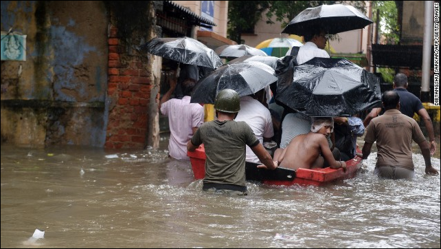 Indian police officials pull a boat through water-logged streets as they ferry residents to a safer place in Kolkata on 26 October 2013. Photo: Dibyangshu Sarkar / AFP / Getty Images