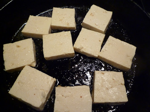 Tofu cooking in skillet