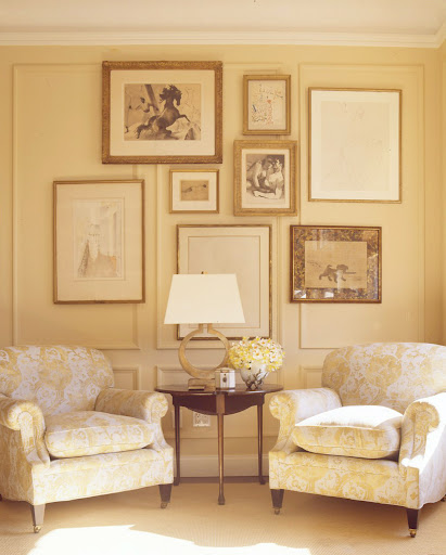 I love the juxtaposition of randomly arranged paintings above a balanced seating area.