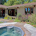 The outdoor area features a jacuzzi set amongst a flower garden.