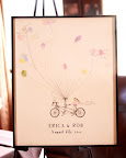 A poster featuring the couple's names, wedding date, and a bicycle built for two served as their guest book. Guests were encouraged to create A poster featuring the couple's names, wedding date, and a bicycle built for two served as their guest book. Guests were encouraged to create