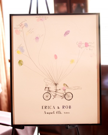 A poster featuring the couple's names, wedding date, and a bicycle built for two served as their guest book. Guests were encouraged to create A poster featuring the couple's names, wedding date, and a bicycle built for two served as their guest book. Guests were encouraged to create