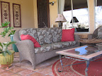 With the exception of the couch and chairs, everything on Lynda's porch comes from a garage sale. The lovely iron wall hangings above the couch were $4 total.