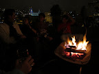 Sitting around the wheel barrow camp fire. The Rapunzil church is in the background.