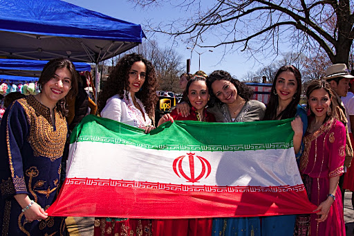 Our Persian friends holding the Iranian flag in front of our booth.