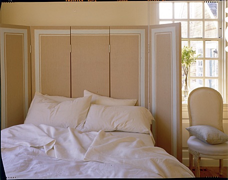 Another unique headboard solution: Using a hinged screen -- I love the frame around it.