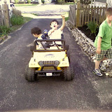 Kai and Eidan riding on the neighbor's battery powered mini Jeep Kai and Eidan riding on the neighbor's battery powered mini Jeep