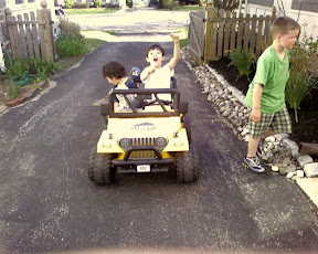 Kai and Eidan riding on the neighbor's battery powered mini Jeep