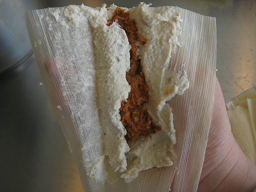 This is where the dampness of the corn husk and the proper texture of the dough are important. Fold one edge of the corn husk over the filling and press lightly to adhere the dough to the filling. It should release easily from the husk