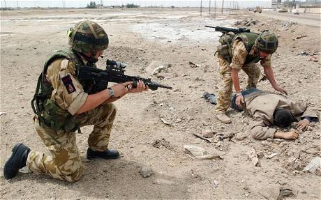 Britain's 2 Company Irish Guards check a man dressed in civilian clothes in Basra on 6 April 2003. Photo: Getty Images