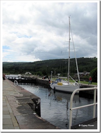 A lone yacht going down the Caledonian canal flight at Fort Augustus.