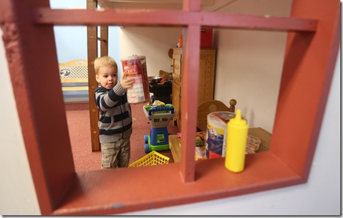 Corbin Williams, 2, puts away his groceries as he plays in the Oodleplex room Tuesday at the Reno County Museum. (Travis Morisse/The Hutchinson News)