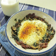 Parmesan baked eggs over bacon, mushroom, leek, and arugula hash