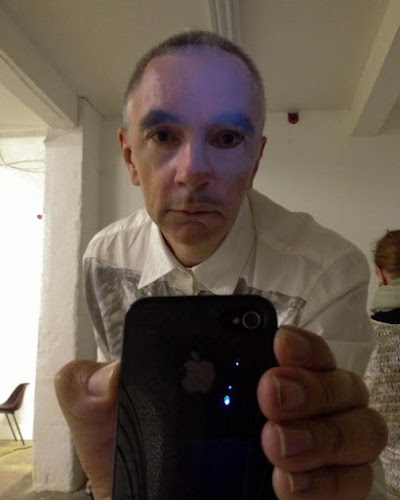 <p>
	Rob Scharein uses a mirror to don a mask</p>
