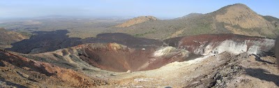 Looking down into the top crater of Cerro Negro. The white deposits in the right hand half of the picture are mainly sulphur deposits from the gas vents. The old lava flows in the background out into the vegetation are from when the one wall of the main crater (which is to the right) collapsed. IMG_2262-IMG_2266_1.jpg