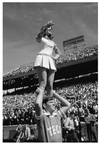 In the instance of one cheerleader standing on another's shoulders, the cheerleader's feet exert downward pressure on her partner's shoulders. the pressure is equal to the girl's weight divided by the surface area of her feet.