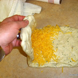 punch dough down from the ball in the bowl, flatten out, then start to layer the cheese as you triple fold it..