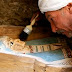 An Egyptian worker brushes an ancient Pharaonic sarcophagus of Illahun mayor's daughter dated to the 22nd Dynasty (ca. 931-725 BC) inside a rock-cut tomb which has been discovered by an Egyptian archaeological mission sponsored by the Supreme Council of Antiquities (SCA) southeastern part of the pyramid field of Illahun, Sunday April 26, 2009, in Egypt's Fayoum region. (AP Photo/Amr Nabil)