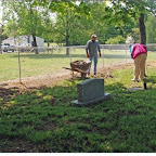 George cleans the cemetery fence row as Roy Ellen Hammann looks on.