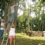 Owen and Betty hold ladder as George mounts the sign.