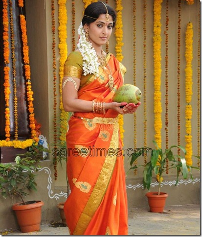 South Indian actress Anushka in orange color bridal sari paired with 