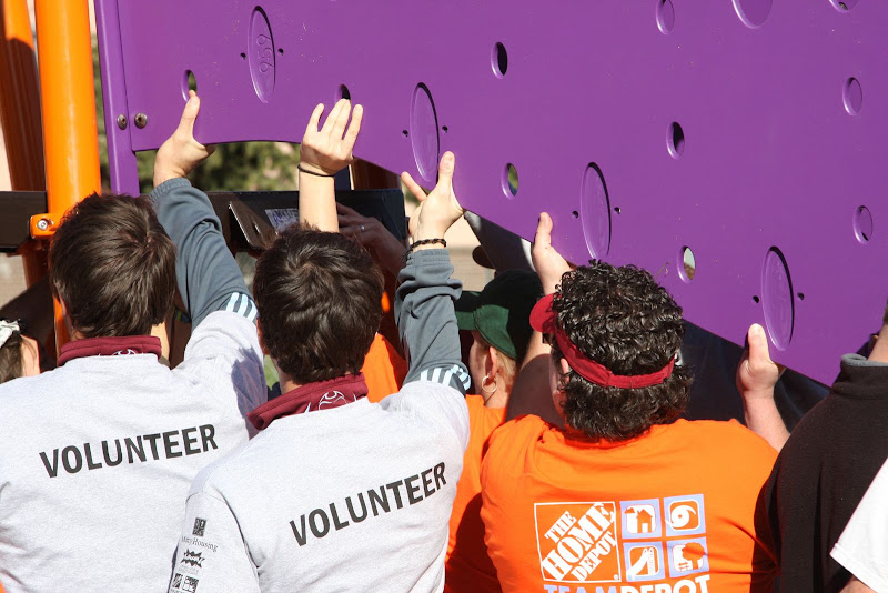 Volunteers help build the new playground at Holly Park Apartments in Commerce City, Colo.