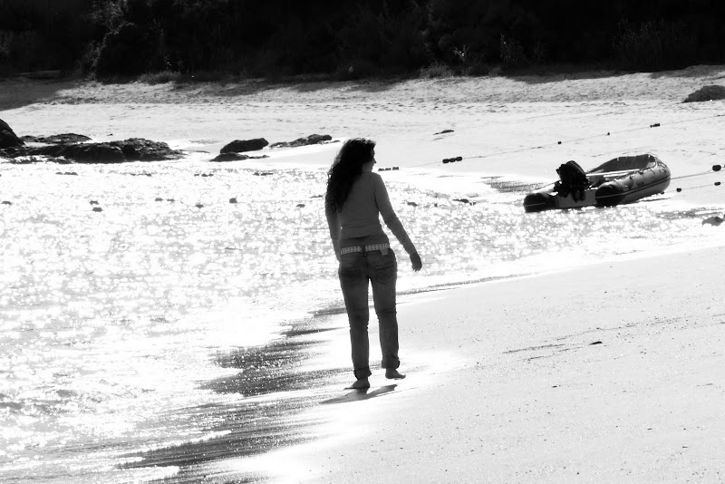 Mulher passeia na praia de Albarquel
