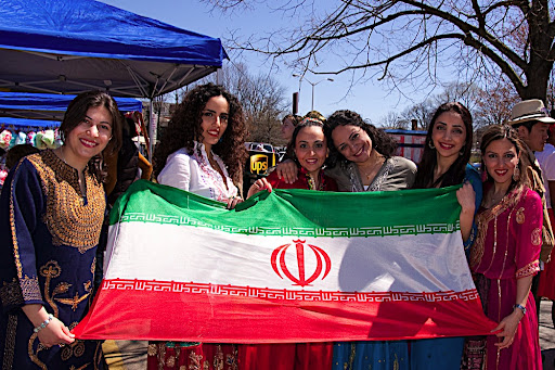 Our Persian friends holding the Iranian flag in front of our booth.